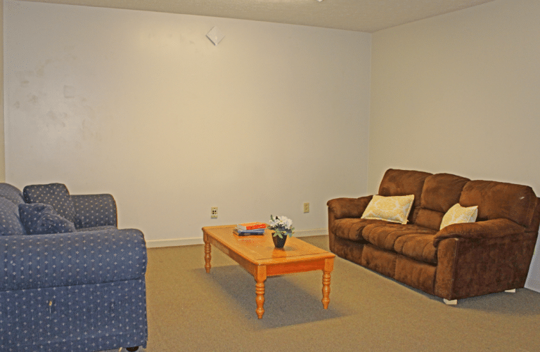 The 客厅 of an apartment in Trustee Hall. There are two couches and a coffee table.